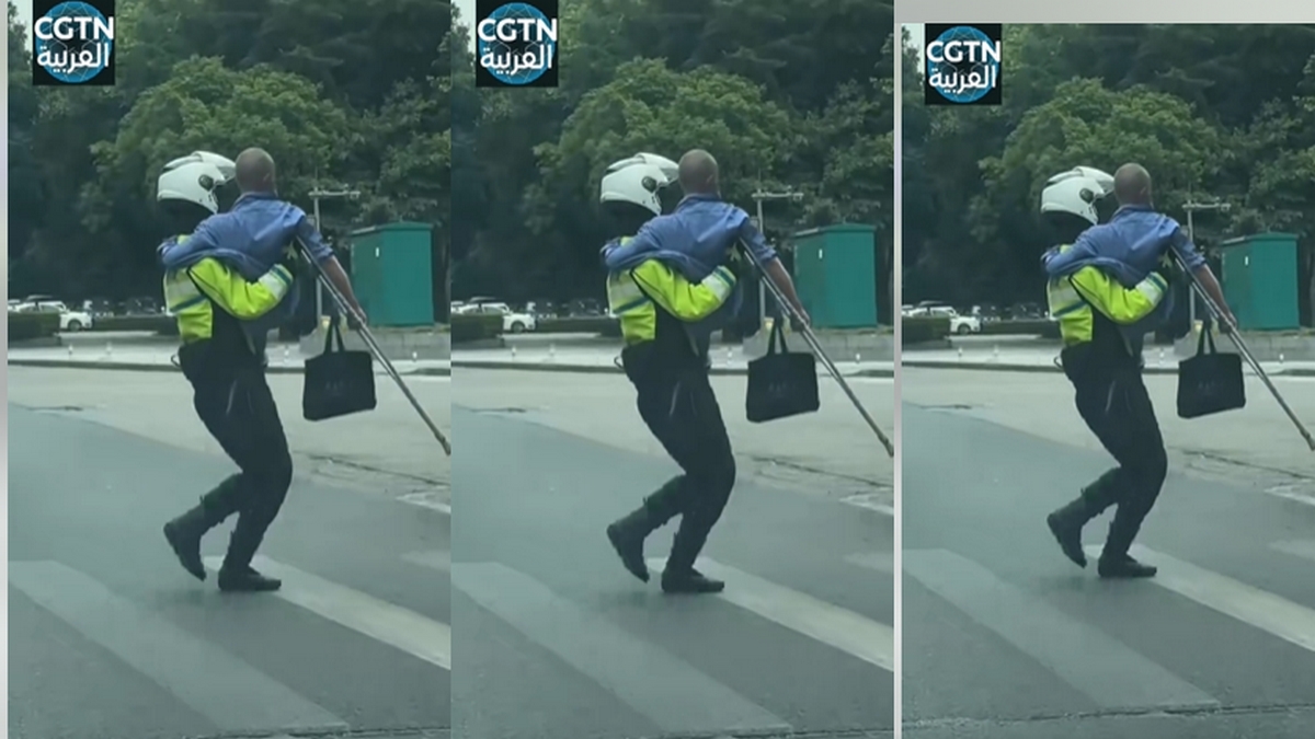 الصين : مشهد دافئ.. شرطي المرور يحمل  عجوزا لعبور الطريق